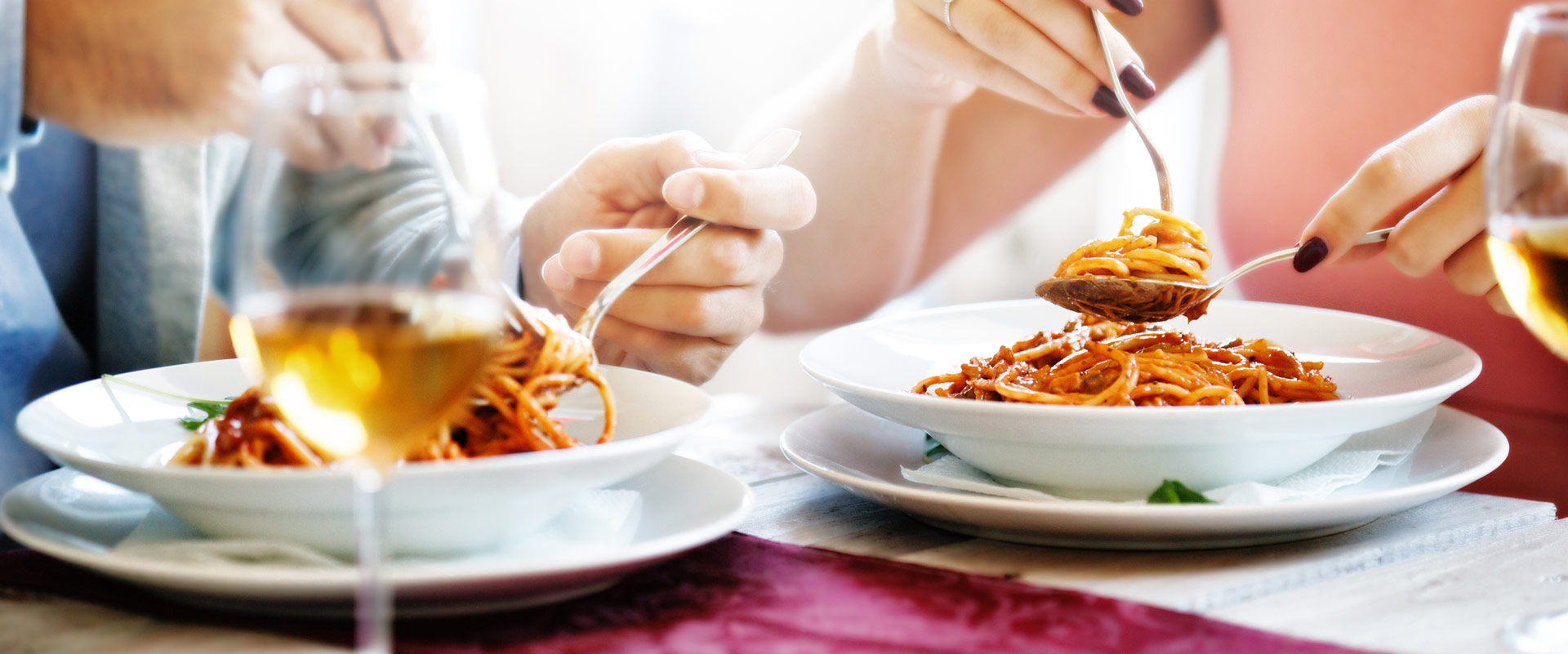 couple eating pasta with wine