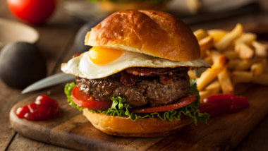 burger with fried egg and bacon with fries