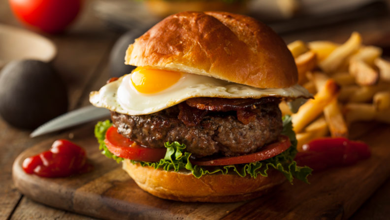 burger with fried egg and bacon and fries