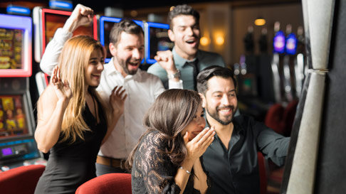 young friends celebrating a win at the slot machine